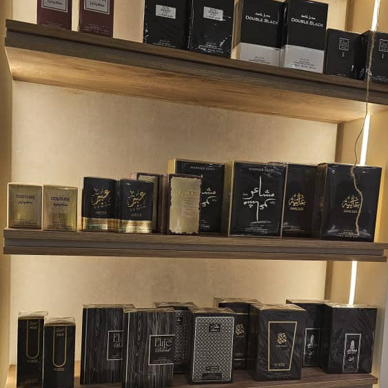 Shelves displaying various black boxes with gold accents in a store setting.